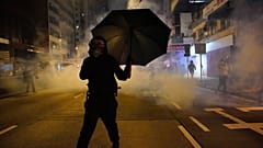 Un manifestante se protege de los gases lacrimógenos en Hong Kong                        