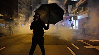 Un manifestante se protege de los gases lacrimógenos en Hong Kong                        