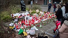 A women lights a candle at the main entrance of the Zoo in Krefeld, Germany, Thursday, Jan. 2, 2020. 