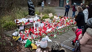 A women lights a candle at the main entrance of the Zoo in Krefeld, Germany, Thursday, Jan. 2, 2020. 