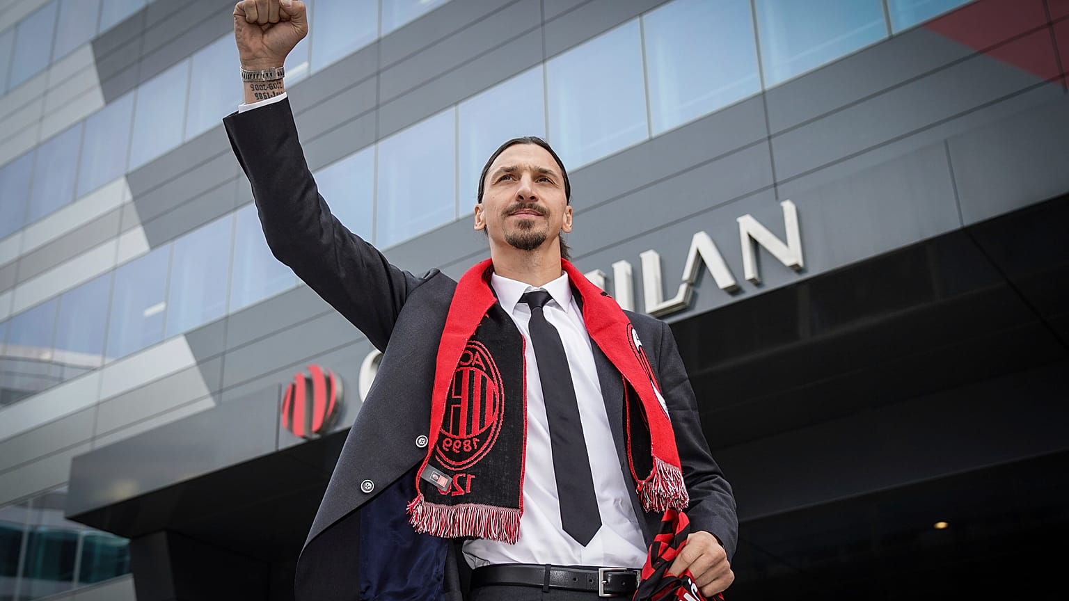 Zlatan Ibrahimovic wears an AC Milan scarf as he acknowledges his fans outside the AC Milan team headquarters, in Milan, Italy, Friday, Jan. 3, 2020.