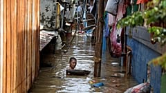 A man swims in flood water in a low-income neighborhood in Jakarta, Indonesia. 2 January 2020. 