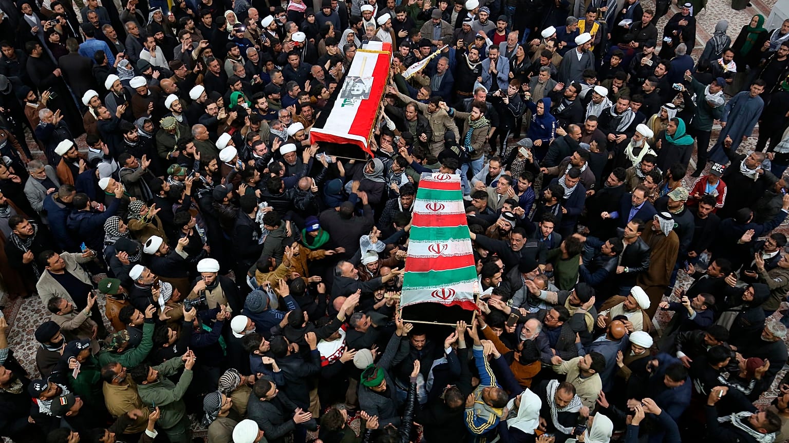 مشيعون يحملون نعشي الجنرال قاسم سليماني وأبو مهدي المهندس في ضريح الإمام علي في النجف، 4 يناير 2020. 
