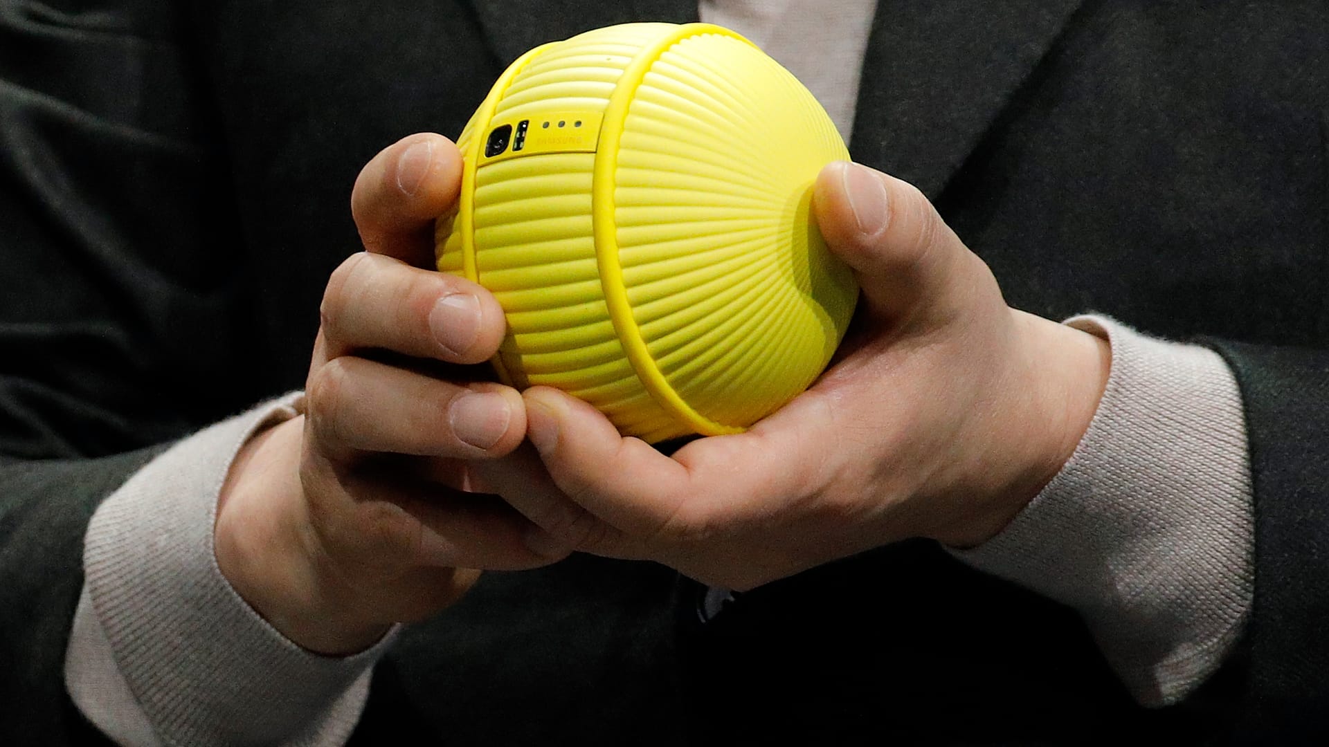 Hyun-Suk Kim, presidente e CEO della divisione Consumer Electronics di Samsung, tiene in mano Ballie, un robot rotante con intelligenza artificiale, durante un keynote di Samsung prima della fiera tecnologica CES, 2020.