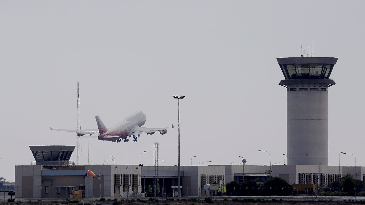 An aircraft take off from Larnaca airport by a tower control is seen at right. Cyprus