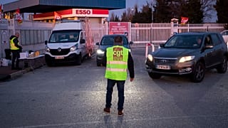 Fransa'da benzin istasyonu önünde grev yapan bir çalışan