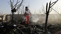 Elementos das equipas de resgate verifica destroços do acidente no Irão