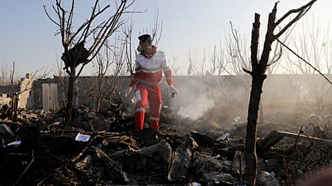 A rescue worker searches the scene where an Ukrainian plane crashed in Shahedshahr, southwest of the capital Tehran, Iran, Wednesday, Jan. 8, 2020. 