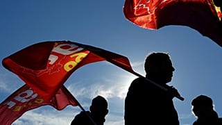 Protesters hold flags during a demonstration in Lyon, central France, Thursday, Jan. 9, 2020.