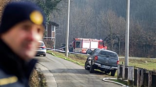 A police officer stands near the burnt nursing home in Andrasevac, northern Croatia.