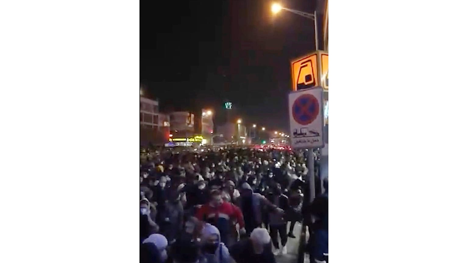 This frame grab from a Sunday, Jan. 12, 2020 video provided by the New York-based Center for Human Rights in Iran shows a crowd fleeing police in Tehran, Iran. 