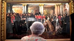 Queen Elizabeth II looks at a painting of Queen Victoria