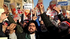 Hardline protesters chant slogans while holding up posters of Gen. Qassem Soleimani in front of British Embassy in Tehran, Iran, Sunday, Jan. 12, 2020