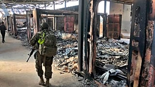 U.S. Soldiers walk past a site of Iranian bombing at Ain al-Asad air base, in Anbar, Iraq, Monday, Jan. 13, 2020.