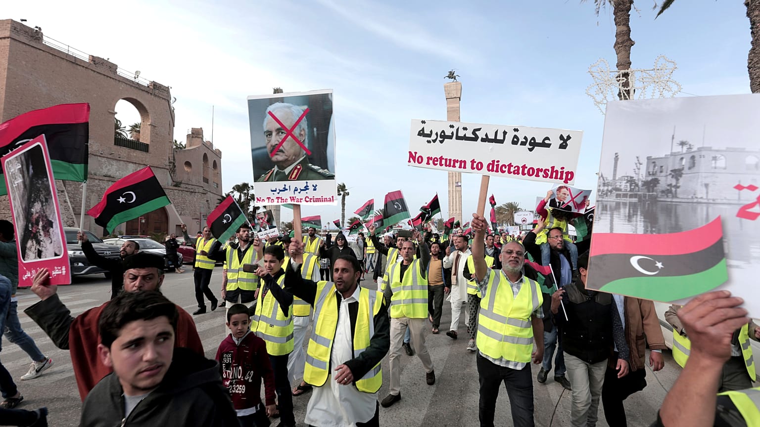 In this April 19, 2019 file photo, protesters wear yellow vests at a protest as they wave national flags and chant slogans against Libya's Field Marshal Khalifa Hafter