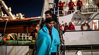 Migrantes de Bangladesh desembarcan del buque de rescate Open Arms en el puerto de Messina después de ser rescatados el viernes frente a la costa de Libia, en Sicilia, Italia