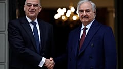Libyan Gen. Khalifa Hafter, right, and Greek Foreign Minister Nikos Dendias shake hands before their meeting in Athens, Friday, Jan. 17, 2020