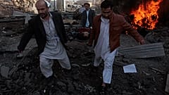 Afganistan'ın başkenti Kabil'de düzenlenen bir intihar saldırısında yaralanan siviller ambulansa taşınırken (arşiv)