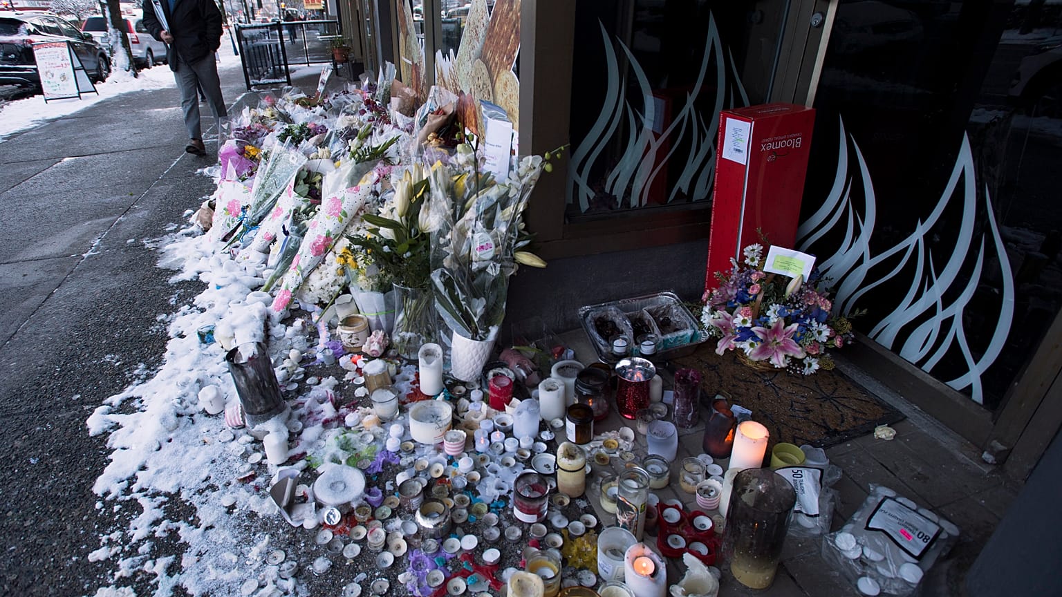 Snow-covered flowers and candles are seen outside of the family bakery of Ayeshe Pourghadheri and her daughter Fatemah Pasavand in North Vancouver, B.C.