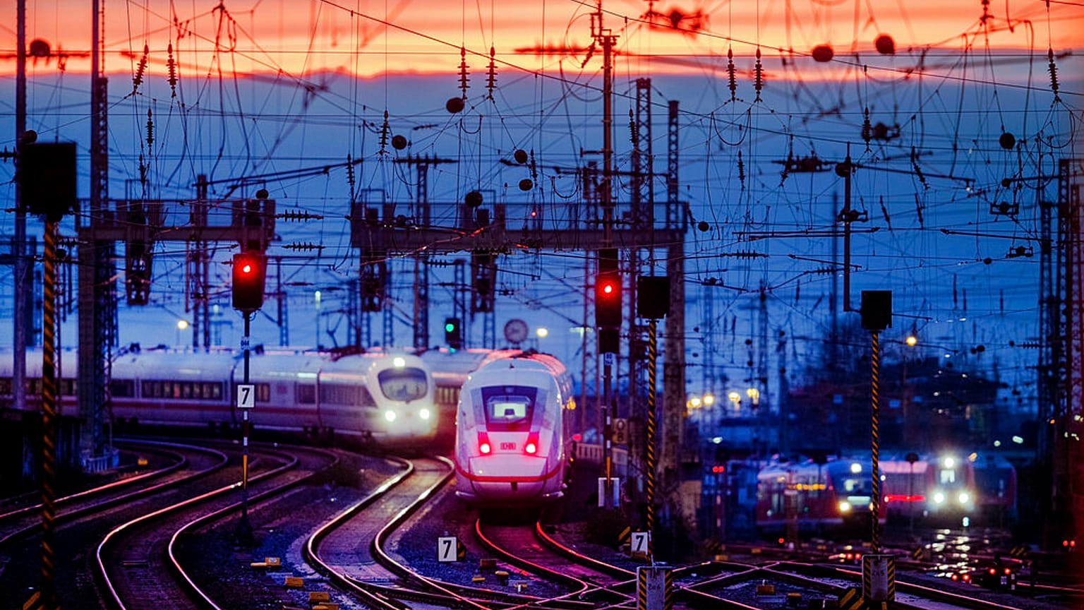 Two train approach the main train station after the sun set in Frankfurt, Germany, Friday, Jan. 17, 2020. (AP Photo/Michael Probst)