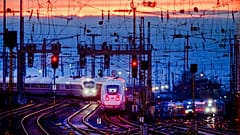 Two train approach the main train station after the sun set in Frankfurt, Germany, Friday, Jan. 17, 2020. (AP Photo/Michael Probst)