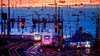 Two train approach the main train station after the sun set in Frankfurt, Germany, Friday, Jan. 17, 2020. (AP Photo/Michael Probst)