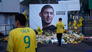 Nantes team supporters in front of a poster of Emiliano Sala that says "Let's keep hope"