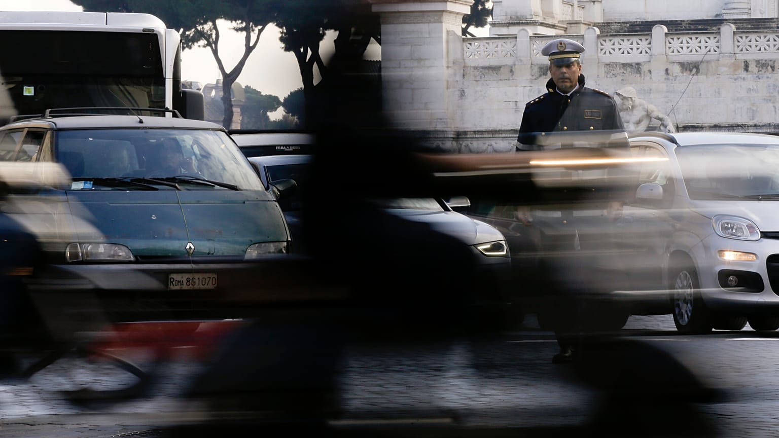 A City Police officer stands among cars as he directs traffic in downtown Rome, Thursday, Dec. 24, 2015.