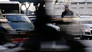 A City Police officer stands among cars as he directs traffic in downtown Rome, Thursday, Dec. 24, 2015.