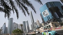 سيارة أجرة تمر بمبنى عليه صورة أمير قطر الشيخ تميم بن حمد آل ثاني في الدوحة، قطر.