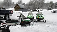 In this Dec. 10, 2014 photo, snowmobiles sit in the yard of Champlain Valley Motorsports in Cornwall, Vt. 