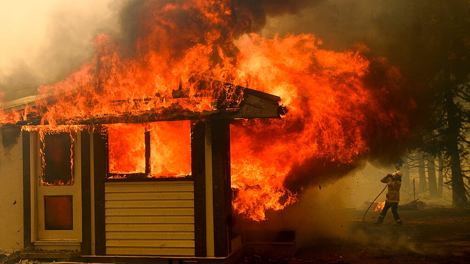 A firefighter battles the Morton Fire as it consumes a home near Bundanoon, New South Wales, Australia. January 23 2020