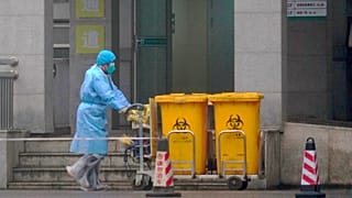 Empleado traslada contenedores en un hospital de Wuhan, China