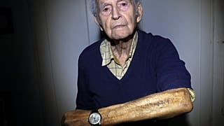 In this Saturday, Jan. 4, 2020 photo Holocaust and Auschwitz survivor Leon Schwarzbaum shows his tattooed identification number in his home in Berlin.