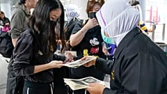 Agentes de inmigración dan información a viajeros en el aeropuerto de Kuala Lumpur