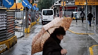 Μία γυναίκα περπατάει στο κέντρο της Θεσσαλονίκης μία βροχερή χειμωνιάτικη ημέρα (αρχείου)