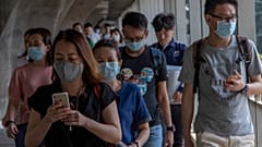 Tayland'da koronavirüse karşı maske takan insanlar