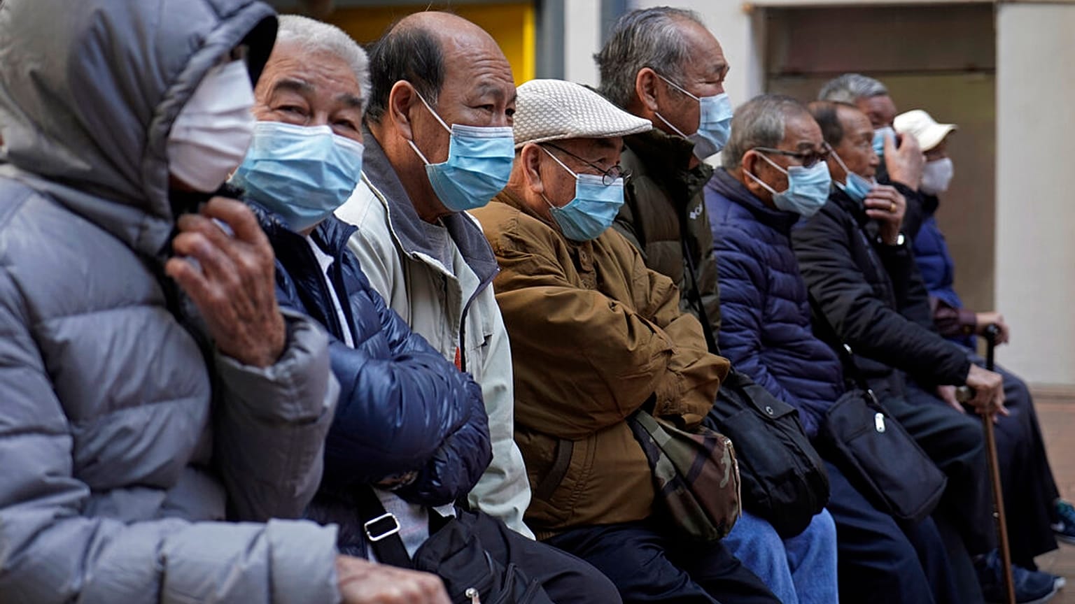 Elderly men sit at a park in Hong Kong, Thursday, Jan. 30, 2020. 