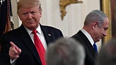 الرئيس دونالد ترامب يشير إلى الحاضرين وهو يقف مع رئيس الوزراء الإسرائيلي بنيامين نتنياهو داخل البيت الأبيض في واشنطن -الثلاثاء 28 يناير 2020