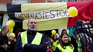 protestors stand in front of a banner which reads "Euthanasia Stop", during an anti-euthanasia demonstration in Brussels in February 2014.