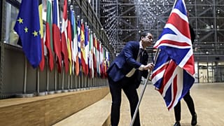 A member of protocol removes the Union flag from the atrium of the Europa building in Brussels, Friday, Jan. 31, 2020.