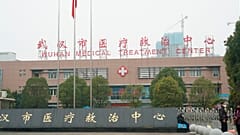 People stand outside the Wuhan Medical Treatment Center, where some infected with a novel coronavirus are being treated, in Wuhan, China, Tuesday, Jan. 21, 2020