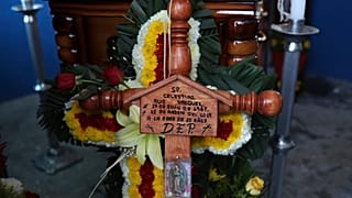 A cross bearing the name of Mexican journalist Jorge Celestino Ruiz Vazquez is displayed near the coffin containing his remains in Actopan, Veracruz, Saturday, Aug. 3, 2019