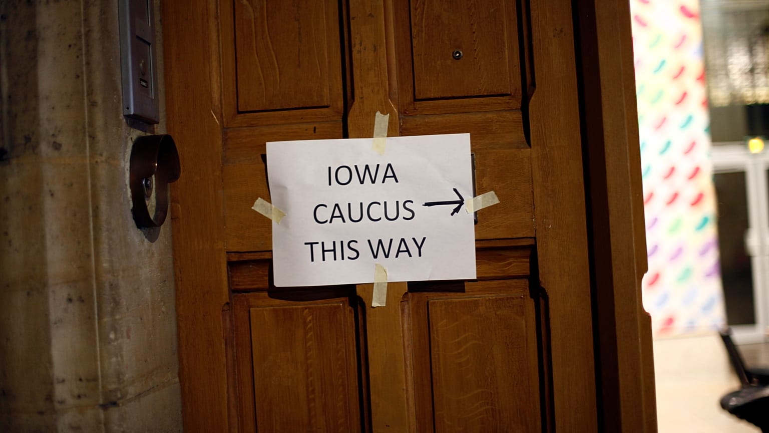 A placard reading « Iowa Caucus this way » hangs on a door, in Paris on Feb. 3, 2020. Paris is one of just three satellite caucus locations outside the U.S.