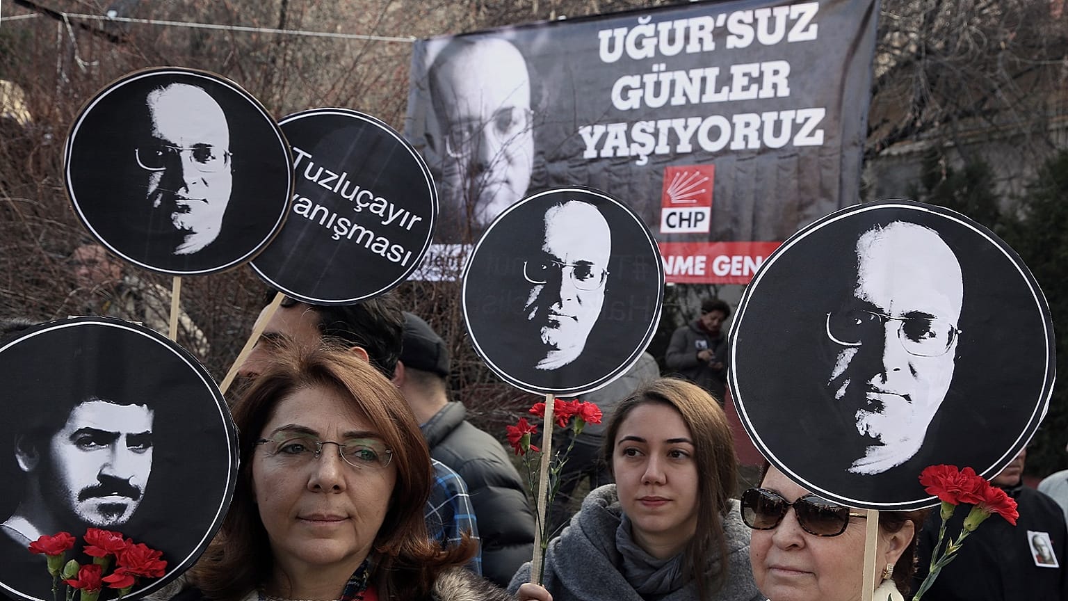 Turkish women hold posters of Ugur Mumcu, Turkey's best-known investigative journalist, who was killed in 1993, and one of Ali Ismail Korkmaz