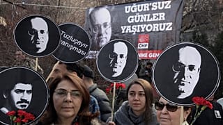 Turkish women hold posters of Ugur Mumcu, Turkey's best-known investigative journalist, who was killed in 1993, and one of Ali Ismail Korkmaz