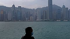 Hong Kong'un Victoria Harbour kıyısında maske giyen bir adam
