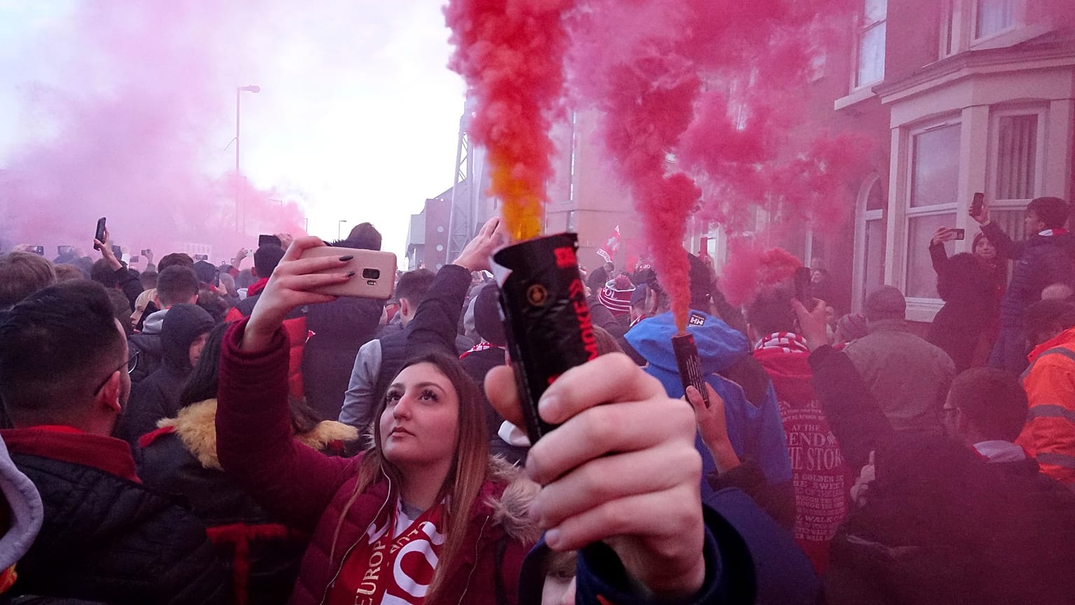 Football supporters set off flares before the English Premier League soccer match between Liverpool and Manchester United near Anfield Stadium in Liverpool.