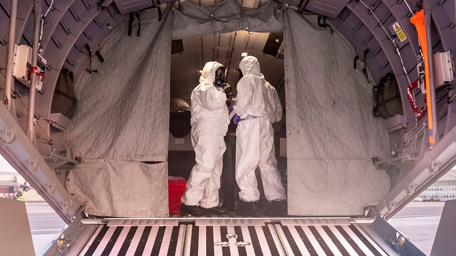 Polish military personnel wearing protective suits stand on board a military aircraft that was used to transport evacuees from Wuhan, China.