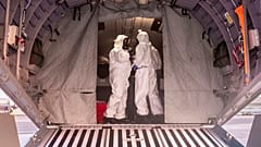 Polish military personnel wearing protective suits stand on board a military aircraft that was used to transport evacuees from Wuhan, China.